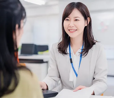 店舗でスタッフが利用者に受付案内をしている様子